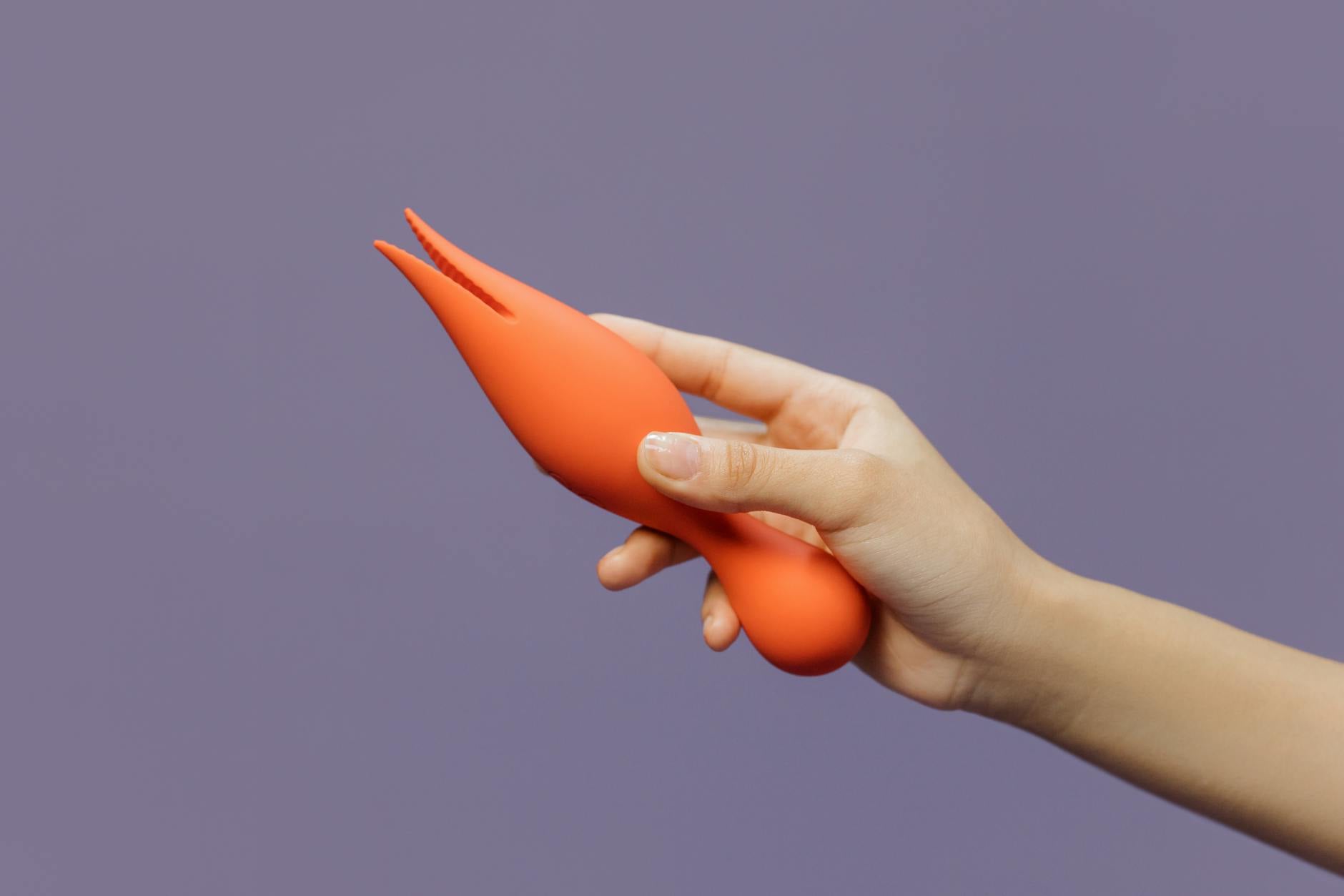Mão segurando um vibrador de limão contra um fundo minimalista, destacando sensualidade moderna