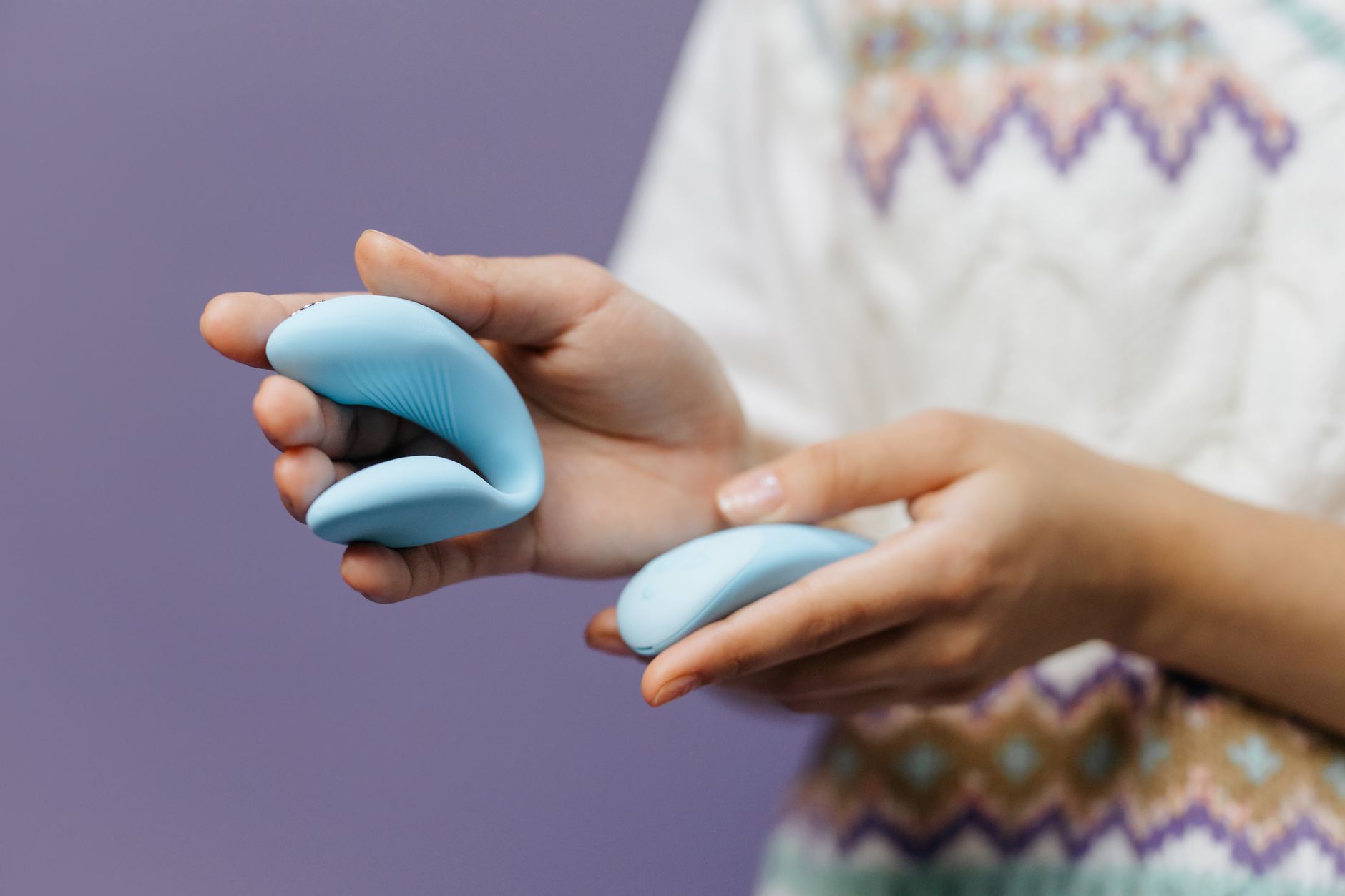 Mãos segurando vibrador de limão em ambiente íntimo