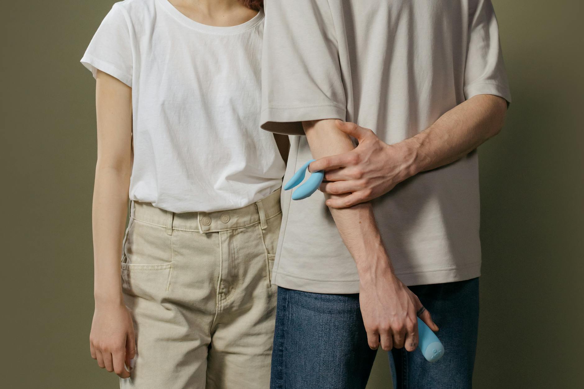Casal jovem em pé juntos, explorando intimidade compartilhada e prazer mútuo com um vibrador moderno.